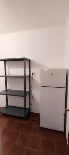 a room with a white refrigerator and a shelf at Große Wohnung mit Garagenparkplatz in Vols am Schlern