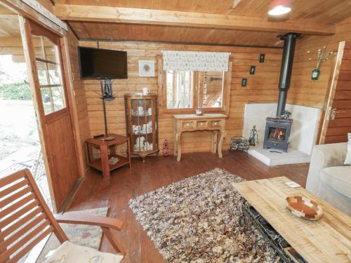 a living room with a couch and a stove at Carps Well Lodge in Warwick