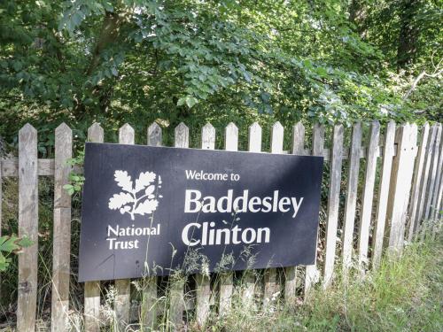 a sign on a fence in front of a garden at Carps Well Lodge in Warwick