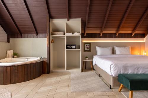 a bedroom with a bed and a bath tub at Resort Ecoar in Gaspar