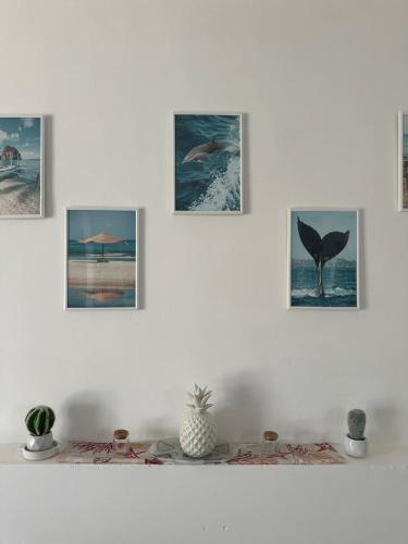 a shelf with pictures on a white wall at Le Terrazze della Dolce Casa - Blue Wave - Casa Vacanza a Marina di Ragusa in Marina di Ragusa