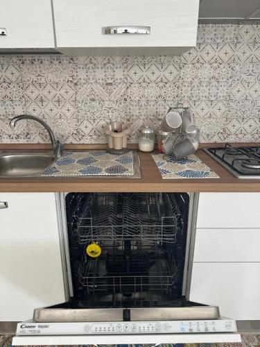 a dishwasher in a kitchen next to a sink at Le Terrazze della Dolce Casa - Blue Wave - Casa Vacanza a Marina di Ragusa in Marina di Ragusa
