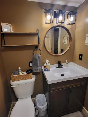a bathroom with a white toilet and a mirror at Moosewood Inn in Saint Ignace