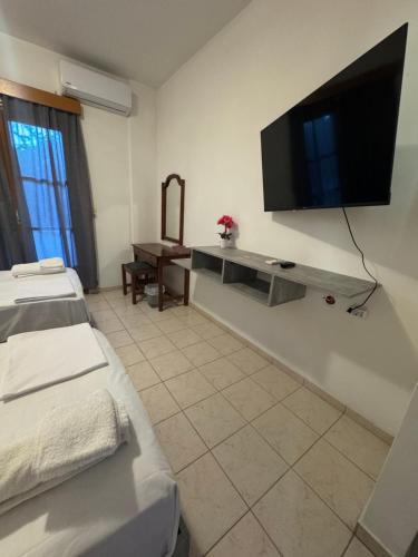 a room with two beds and a television on the wall at Breathe easy living in Tigaki