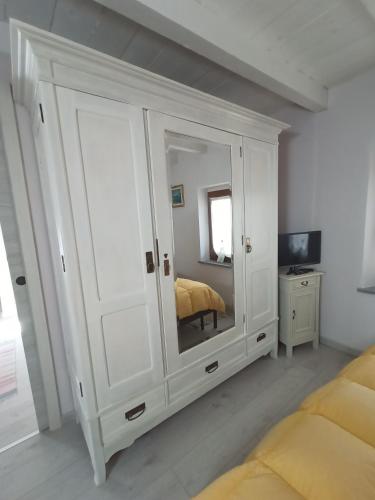 a bedroom with a large white cabinet with a mirror at Casa Pepita in San Bernardino Verbano