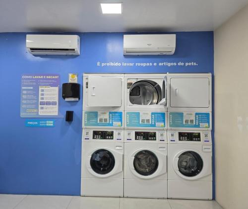 a room with four washing machines and a wall at Flat Hotel Millennium in Manaus