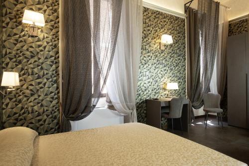 a bedroom with a bed and a table and a window at Antica Dimora Delle Cinque Lune in Rome