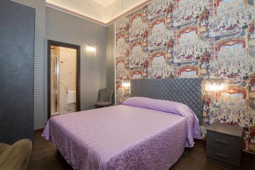 a bedroom with a bed with a purple bedspread at Antica Dimora Delle Cinque Lune in Rome