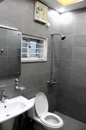 a bathroom with a toilet and a sink and a shower at Islamabad Elite Suites in Islamabad