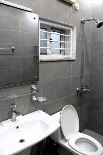 a bathroom with a toilet and a sink and a mirror at Islamabad Elite Suites in Islamabad