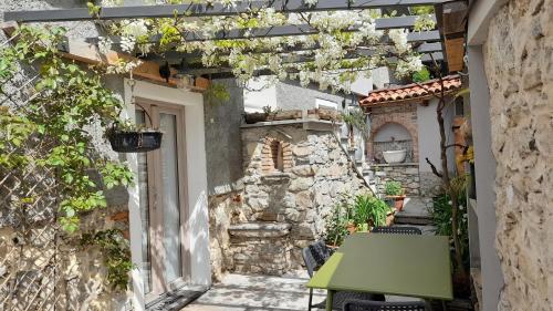 an alley with a green table and a building at BnB Tana del Gufo in Abbadia Lariana