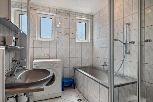 a bathroom with a tub and a sink and a shower at Ferienhaus Svea in Cuxhaven