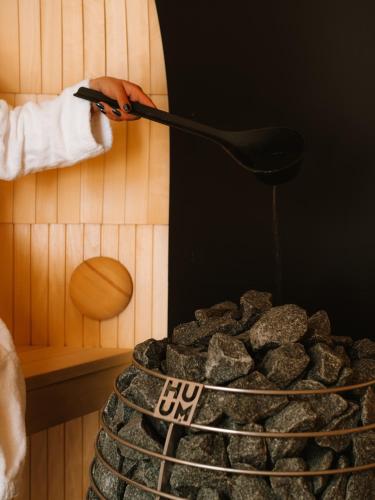 a person cooking food on a grill with a spatula at Hotel Capris Capodistria Boutique in Koper