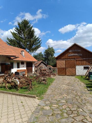 a barn and a barn with a pile of wood at Spaní na seně in Milešín