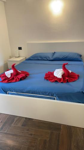 a bed with red and white clothes on it at Casa Borgata in Grondona