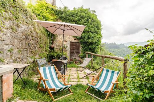 two chairs and a table and an umbrella at Antica Dimora Il Murrotto in Lanciole