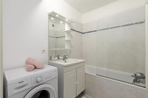 une salle de bain avec une machine à laver et un lavabo dans l'établissement Grand appartement Rouen Free Parking Privé Gratuit, à Rouen