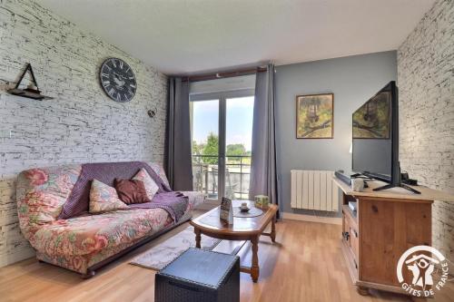 a living room with a couch and a tv at Le haut de breizh in Sens-de-Bretagne
