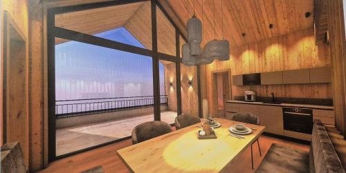 a dining room with a table and a large window at Rufana Alpin in Bürserberg