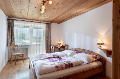a bedroom with a bed and a chair and a window at Haus Sonne in Kirchdorf in Tirol