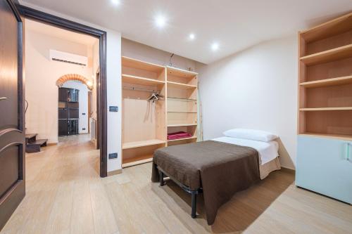 1 dormitorio con 1 cama, TV y estanterías en Alkantara Holiday Home, en Francavilla di Sicilia