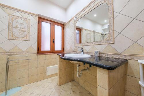 un baño con lavabo y espejo en Alkantara Holiday Home, en Francavilla di Sicilia