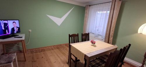 a dining room with a table and a tv at Neukalener Stadthaus Zum Alten Schmied in Neukalen