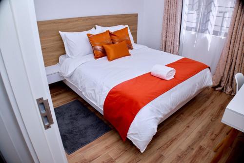 a bedroom with a large bed with orange pillows at Modern and Luxurious 2 Bedroom in Tatu City