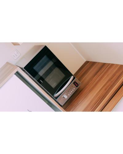 a microwave oven sitting on top of a wooden floor at Camping Santa Elena in Lloret de Mar