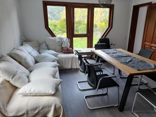a living room with a couch and a table and chairs at Lotru Relax Chalet in Malaia