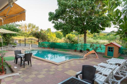 a pool with chairs and a table and a playground at Family Hotel Mimosa in Tsarevo