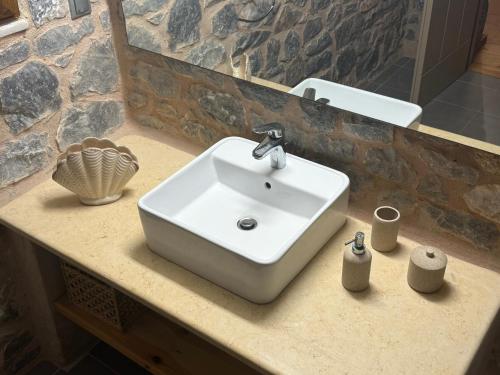 a white sink on a counter in a bathroom at Pirgos Petropoulea in Poliána