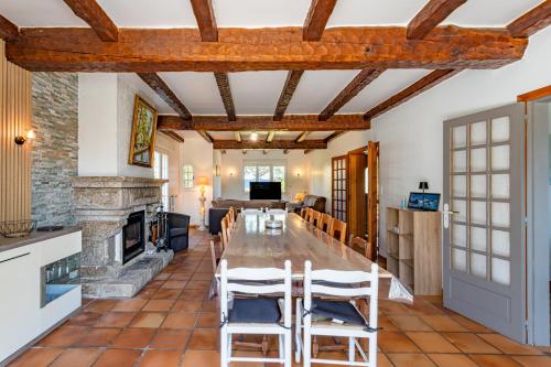 une salle à manger avec une grande table et une cheminée dans l'établissement Pradic 15 personnes , Cheminée , Jardin , Plage à pied, à Étel