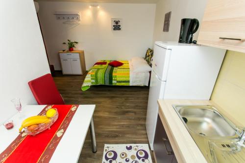 una pequeña cocina con mesa y nevera en Apartments Tomaš, en Trogir