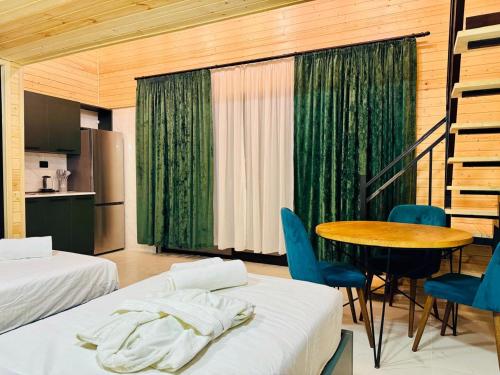 a room with two beds and a table and chairs at 13th Turn in Borjomi