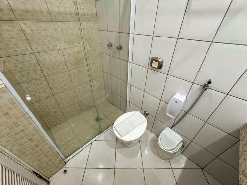 a small bathroom with a toilet and a shower at Hotel Nacional Inn Guarujá in Guarujá
