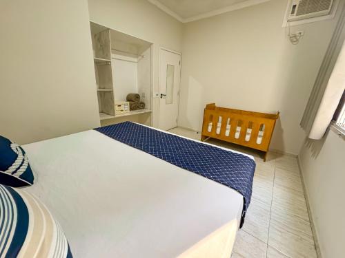 a bedroom with a large white bed and a chair at Hotel Nacional Inn Guarujá in Guarujá