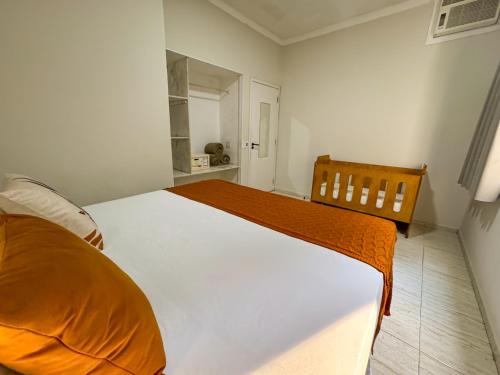 a bedroom with a large bed with an orange blanket at Hotel Nacional Inn Guarujá in Guarujá