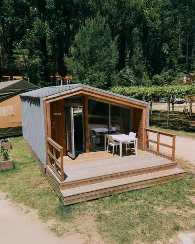a small wooden cabin with a table on a deck at Camping Santa Elena in Lloret de Mar