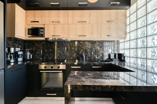 a kitchen with a marble counter top and wooden cabinets at September15 Suites- Meganisi in Meganisi
