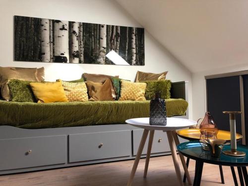 a living room with a green couch and a table at appartement cosy in Saint-James