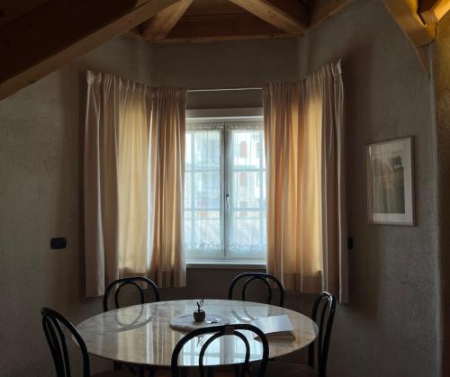 a dining room table with chairs and a window at Castel Madonna in San Martino di Castrozza