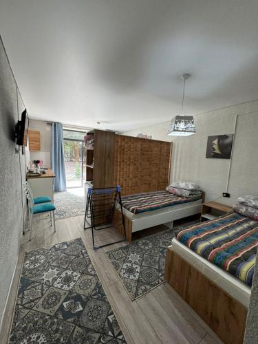 Un dormitorio con dos camas y una mesa y una silla. en Летняя сказка, en Cholpon-Ata