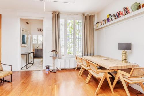 une salle à manger avec une table et des chaises en bois dans l'établissement Paul Escudier - Spacieux et lumineux appartement au cœur de Paris, à Paris