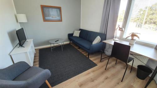 a living room with a blue couch and a table at Vanha-Merivartioasema in Kotka