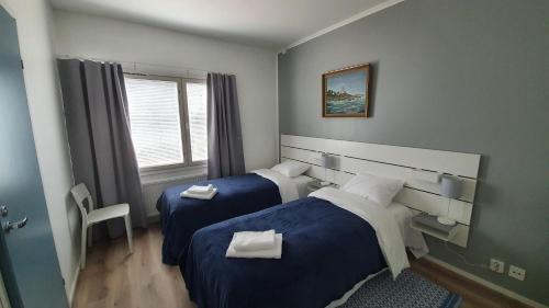 a hotel room with two beds and a window at Vanha-Merivartioasema in Kotka