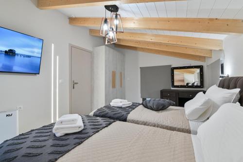 a bedroom with two beds and a flat screen tv at September15 Suites- Meganisi in Meganisi