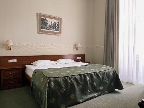 a bedroom with a bed with a green comforter at Continental Hotel in Odesa