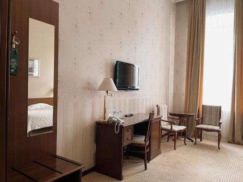 a hotel room with a desk and a bed at Continental Hotel in Odesa