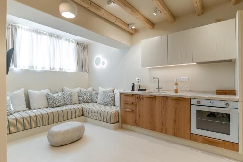 a living room with a couch and a kitchen at Antony Suites (Adults Only) in Naxos Chora